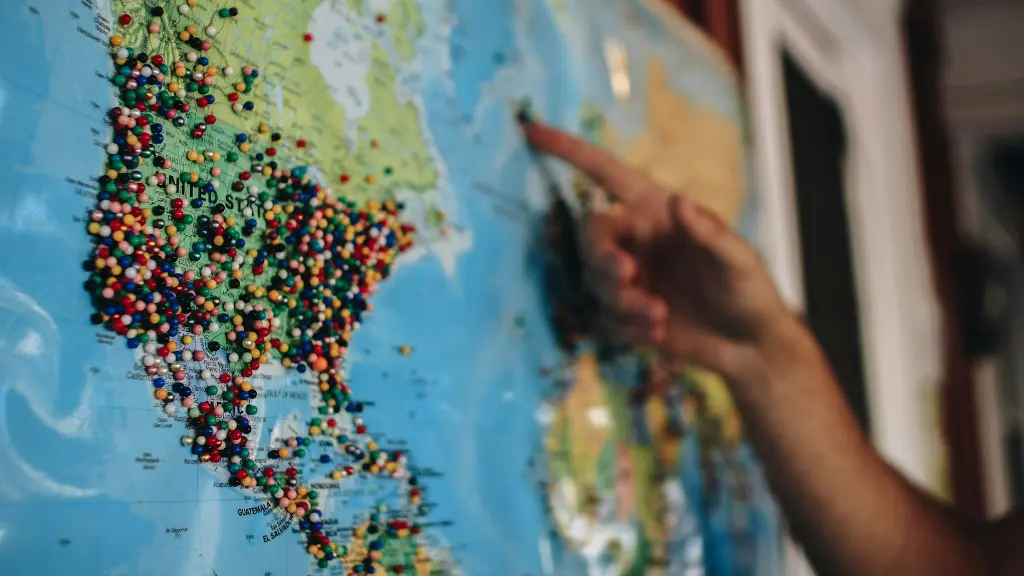 a person pointing at a map with pins on it